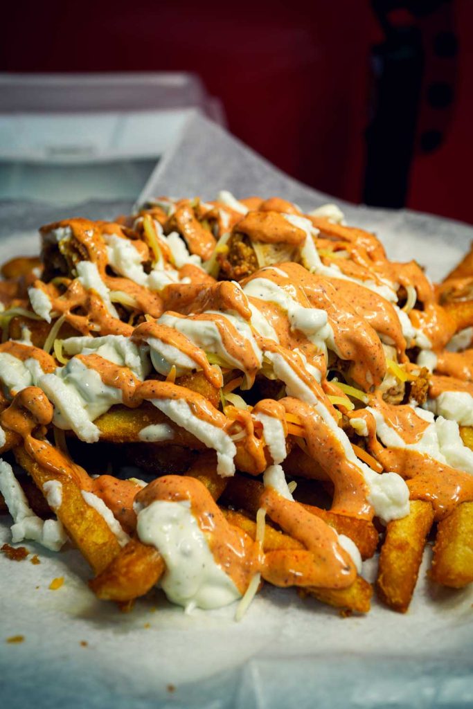Loaded fries with chicken, cheese, and sauce â€“ Boss Bites specialty