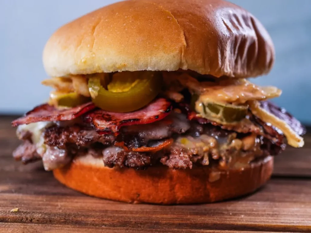 Mouth-watering burger with a smashed patty, bacon, cheese, and spicy jalapeños, a popular menu item at the best burger joints near Laterna Villa