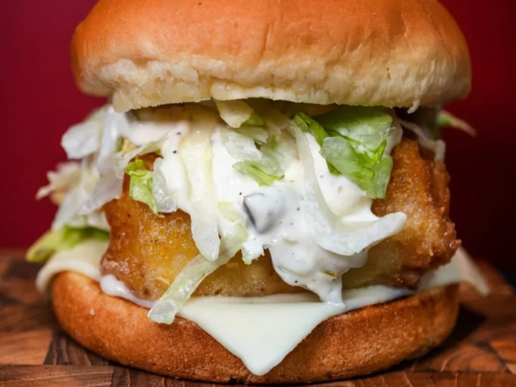 A beautiful fish burger, overflowing with creamy tartar sauce and crisp lettuce, which is a perfect example of what makes our place one of the best burgers near Waterford