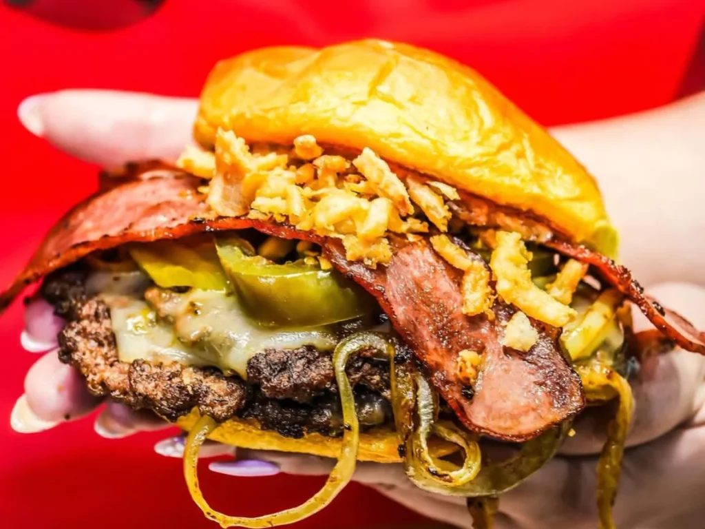 A mouthwatering double cheeseburger stacked with crispy bacon, jalapeños, fried onions, and melted cheese, served fresh at a burger diner near Waterford