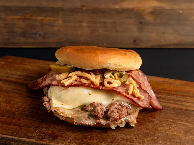 A loaded burger with a beef patty, melted cheese, bacon, crispy fried onions, and jalapeños, a perfect choice for late night burgers in Sugar Land