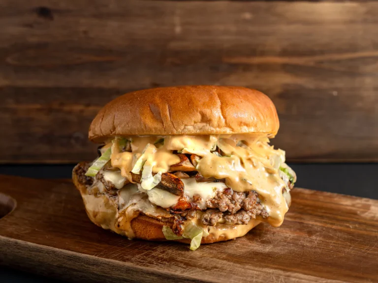 A decadent and saucy double cheeseburger with melted cheese, lettuce, and a special sauce, a perfect example of what you can find at Sugar Land Burger Joints