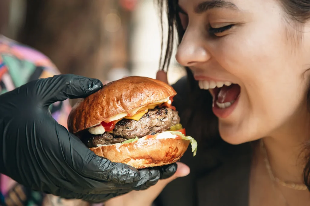 A chef grilling juicy Halal burgers at a lively restaurant in Sugar Land, showcasing fresh flavors.
