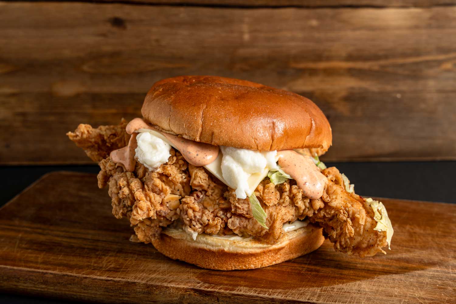 Tasty affordable burger with crispy chicken, creamy sauce, and coleslaw on a bun, served in Sugar Land, TX.
