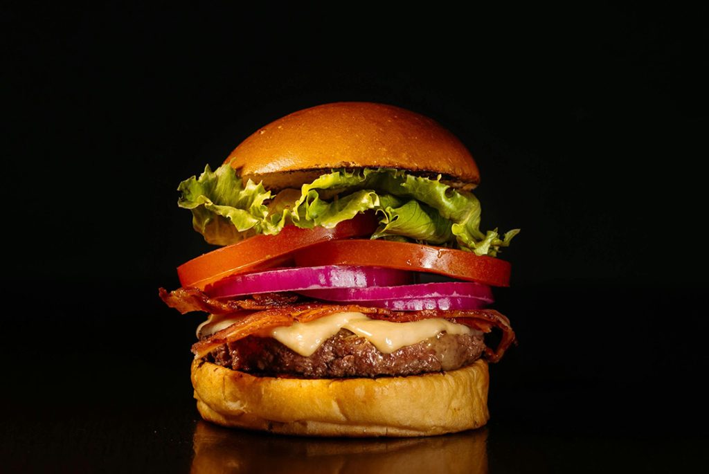 Juicy beef patty with melted cheese, crispy bacon, tomato, red onion, and lettuce—top choice for affordable burgers Sugar Land TX.